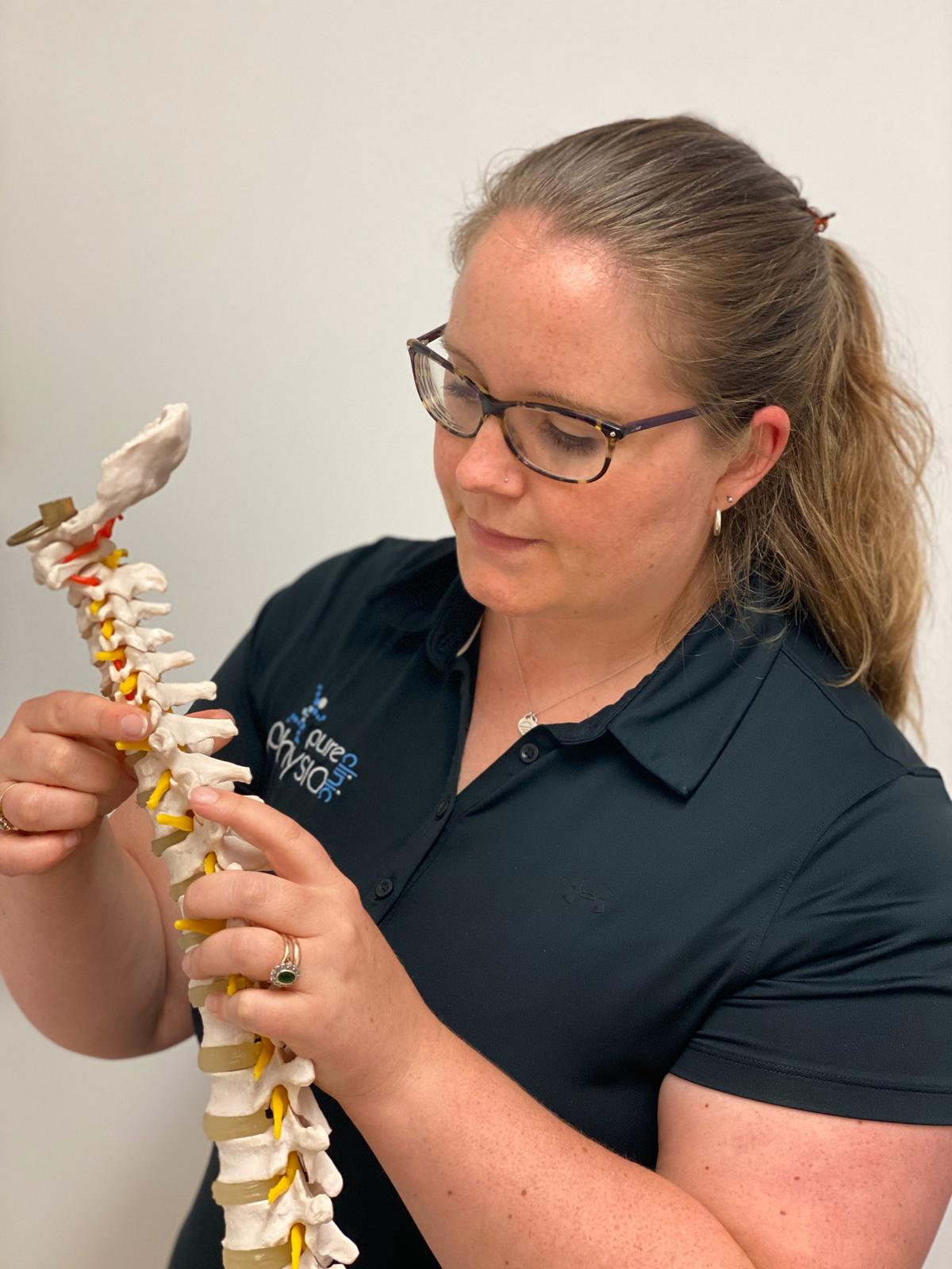 Physio Rebecca McNamara holding a spine